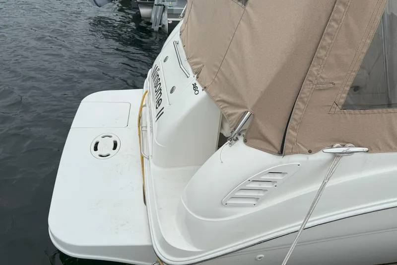 Slide: The Image of 2003 Sea Ray 260 Sundancer boat docked with beige canopy. - 6