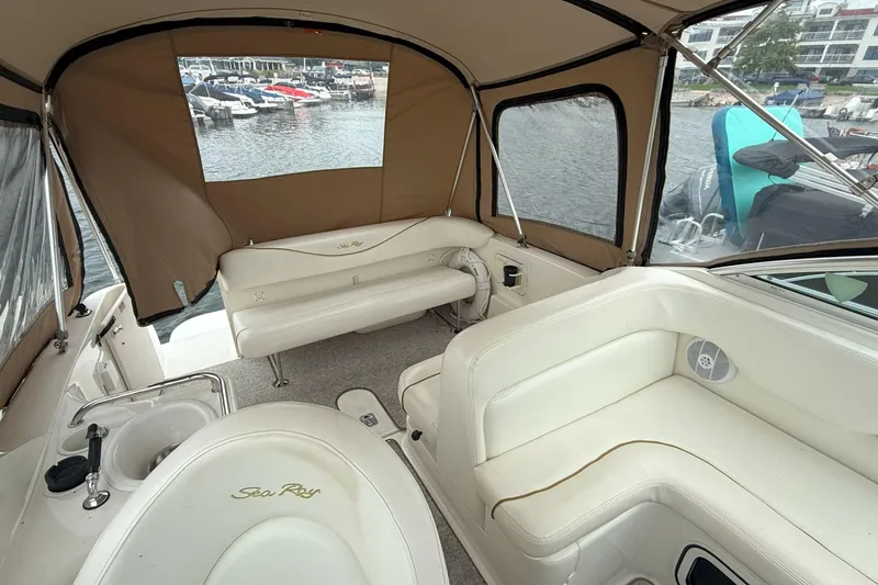 Slide: The Image of 2003 Sea Ray 260 Sundancer interior with beige seating and marina view. - 7