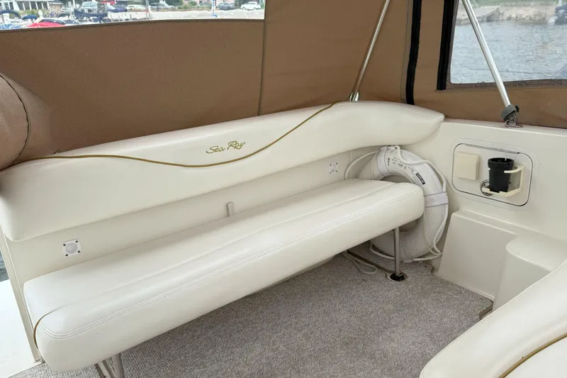 Slide: The Image of Interior of a 2003 Sea Ray 260 Sundancer boat with white seating and brown accents. - 8