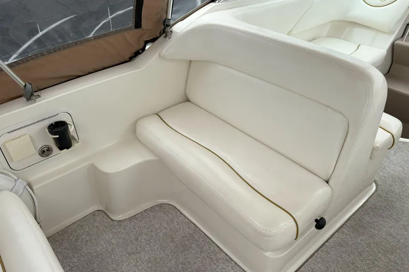 Slide: The Image of 2003 Sea Ray 260 Sundancer interior with white seating and cup holder. - 9