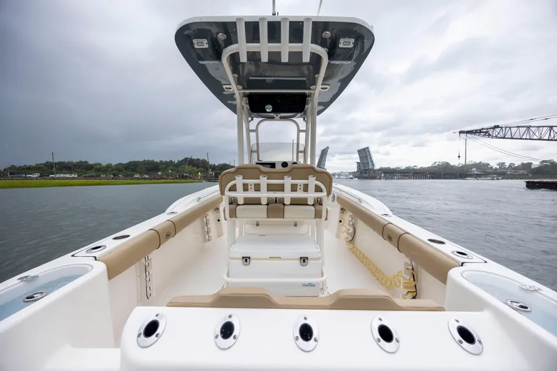 Slide: The Image of 2017 Key West 244 Center Console boat on water, cloudy sky, open bridge in background. - 12