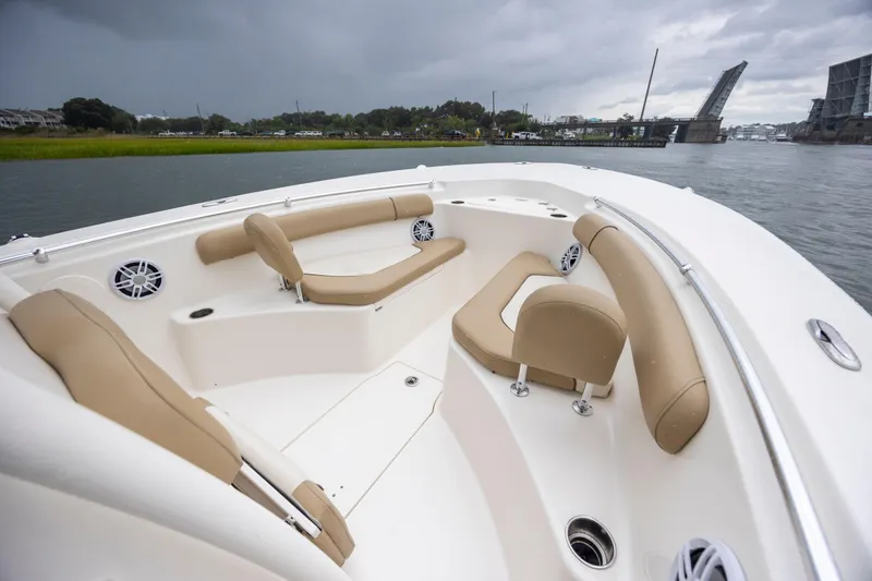 Slide: The Image of 2017 Key West 244 Center Console boat with beige seating, near a drawbridge on a cloudy day. - 17