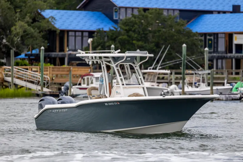 Slide: The Image of 2017 Key West 244 Center Console boat on water near dockside buildings. - 5