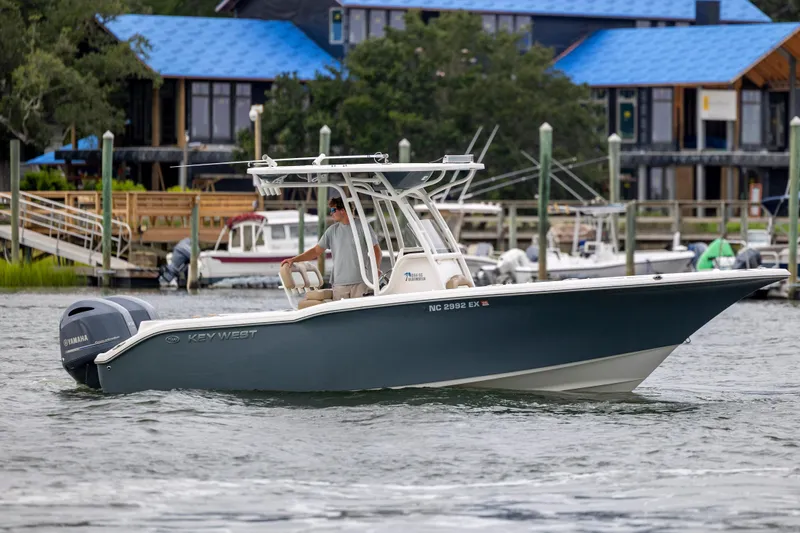 Slide: The Image of 2017 Key West 244 Center Console boat cruising near docks with Yamaha engine. - 6