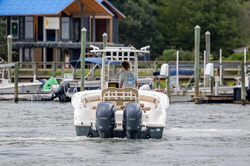 Slide: The Image of 2017 Key West 244 Center Console boat navigating a marina with docked boats. - 8