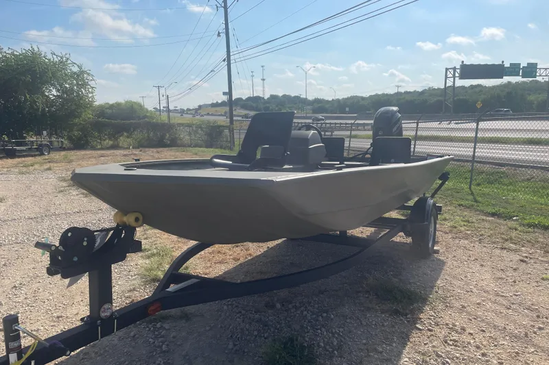 Slide: The Image of 2026 Tracker Grizzly 1754 SC boat on trailer, parked outdoors under clear sky. - 2