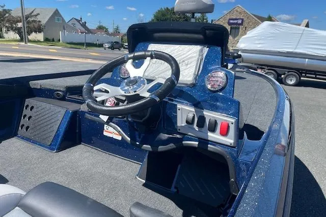 Slide: The Image of 2026 Nitro Z18 Pro boat dashboard with steering wheel and controls, parked outdoors. - 13