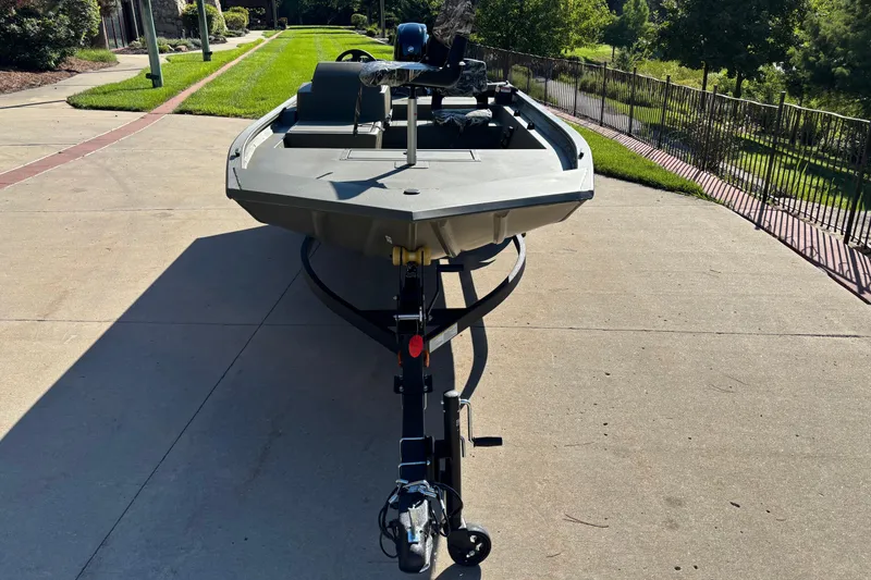Slide: The Image of 2026 Tracker Grizzly 1754 SC boat on trailer, parked on a sunny driveway. - 2