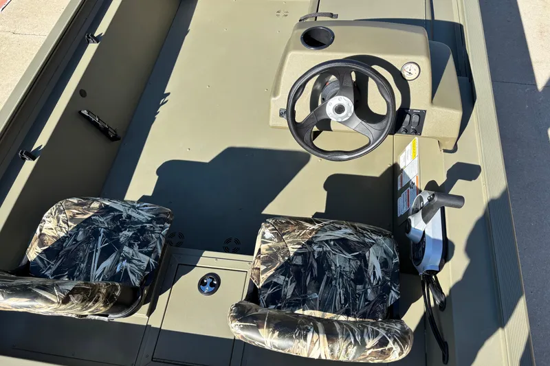 Slide: The Image of 2026 Tracker Grizzly 1754 SC boat interior with camo seats and steering console. - 5