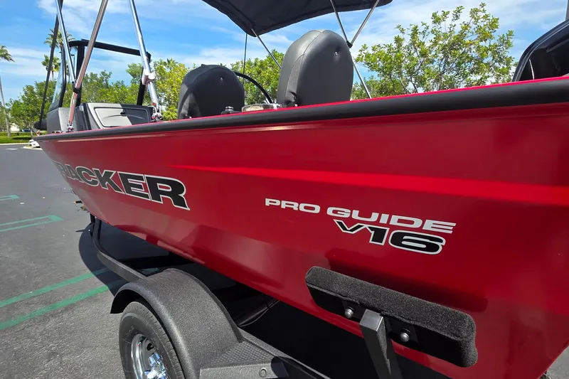 The Image of 2026 Tracker Pro Guide V-16 WT boat, red exterior, parked outdoors. - 0