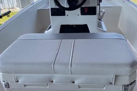 Slide: The Image of 2026 Mako Pro Skiff 15 CC boat interior with steering console and cushioned seating. - 3