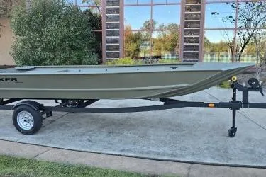 Slide: The Image of 2026 Tracker Grizzly 1648 Utility boat on trailer, parked outdoors. - 2