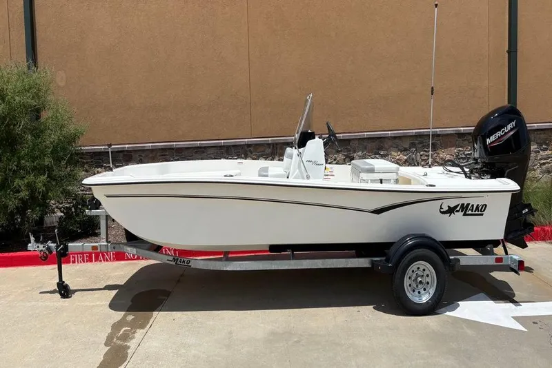 Slide: The Image of 2026 Mako Pro Skiff 17 CC boat on trailer, parked outdoors. - 0