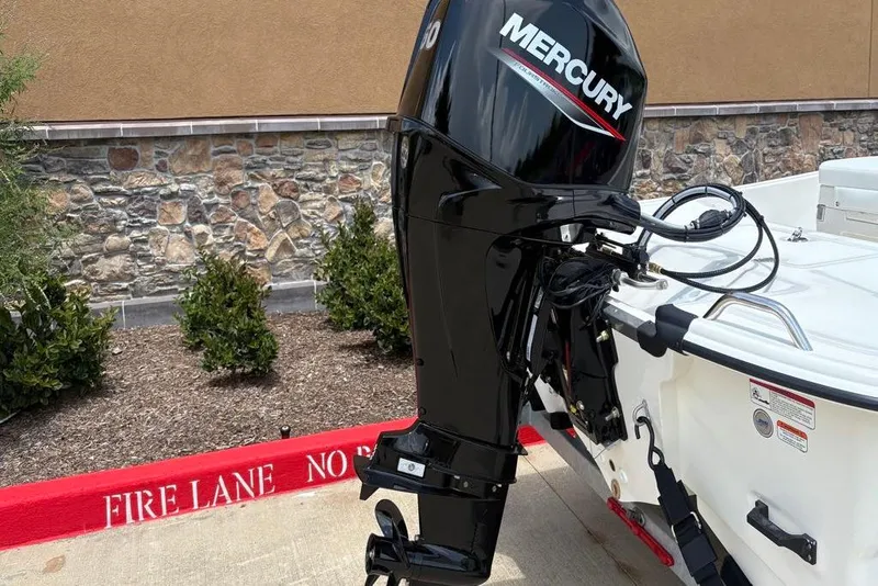 Slide: The Image of 2026 Mako Pro Skiff 17 CC with Mercury outboard motor in a parking area. - 7