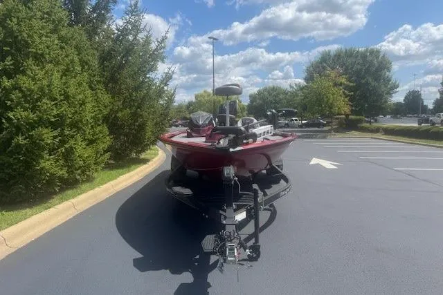 Slide: The Image of 2025 Ranger ALPHA 208 boat parked on a sunny day in a parking lot. - 2