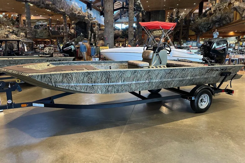 The Image of 2026 Tracker Grizzly 1860 CC boat with camouflage design on display indoors. - 0