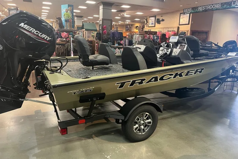 Slide: The Image of 2026 Tracker Pro Team 175 boat displayed indoors with Mercury engine. - 3