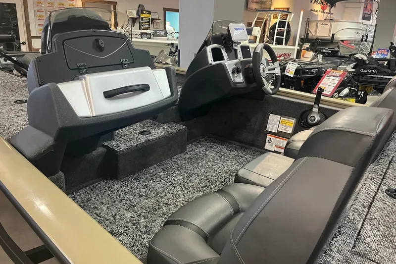 Slide: The Image of 2026 Tracker Pro Team 175 boat interior with steering console and seating in showroom. - 5
