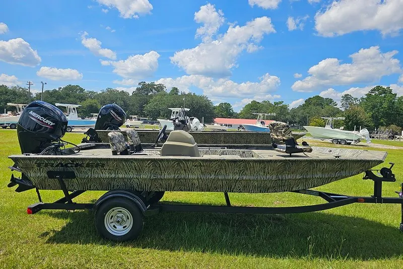 The Image of 2026 Tracker Grizzly 1754 SC boat on trailer, parked on grass under blue sky. - 1