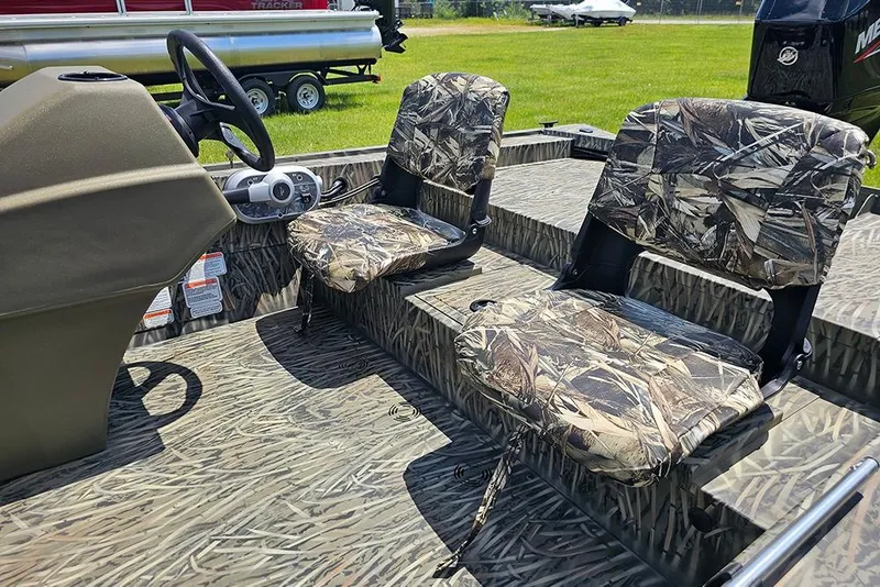 Slide: The Image of 2026 Tracker Grizzly 1754 SC boat interior with camo seats and steering console. - 10