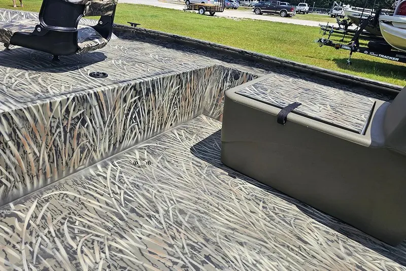 Slide: The Image of 2026 Tracker Grizzly 1754 SC boat interior with camouflage design and seating. - 11