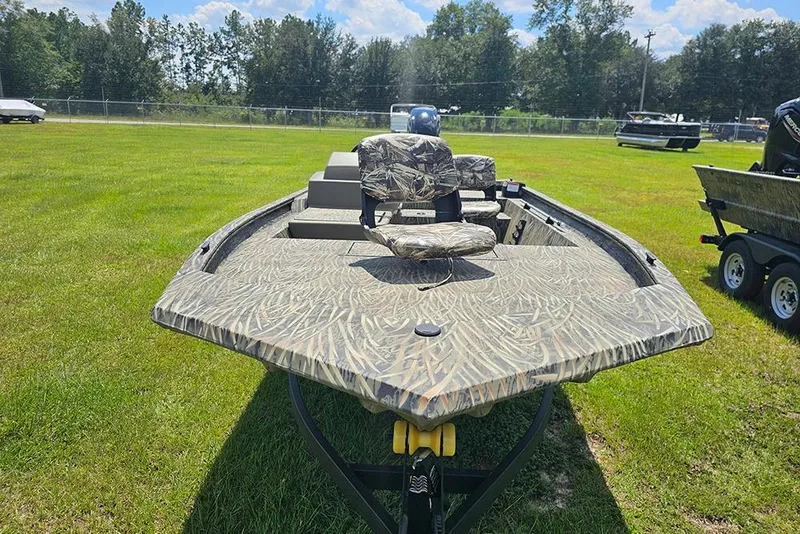 Slide: The Image of 2026 Tracker Grizzly 1754 SC boat with camouflage design on grassy field. - 4