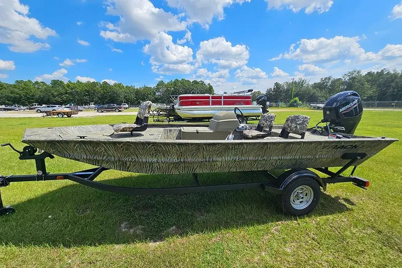 Slide: The Image of 2026 Tracker Grizzly 1754 SC boat on trailer, parked on grass under blue sky. - 6