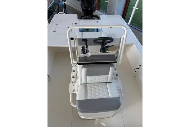Slide: The Image of 2026 Mako 18 Pro Skiff boat interior with steering console and cushioned seating. - 8