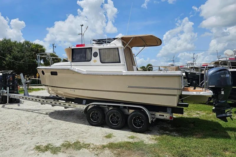 Slide: The Image of 2026 Ranger Tugs R-23 boat on trailer under a clear blue sky. - 4
