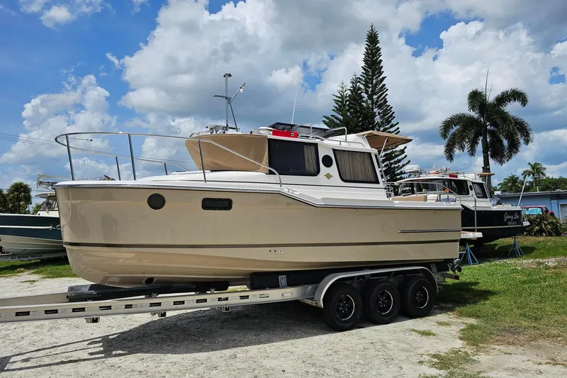 Slide: The Image of 2026 Ranger Tugs R-23 boat on trailer under a cloudy sky. - 5