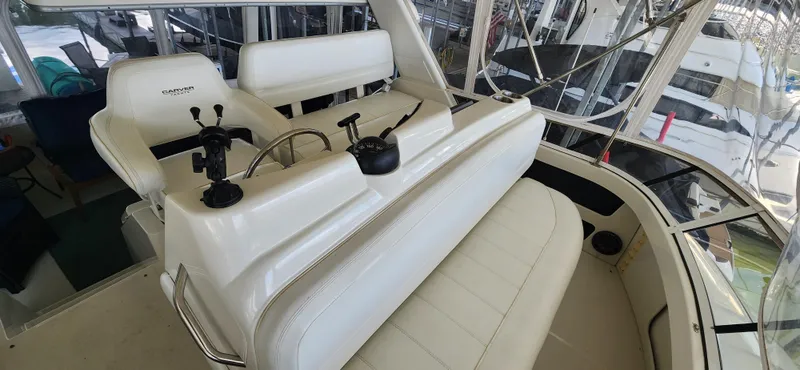 Slide: The Image of 1998 Carver 355 Aft Cabin Motor Yacht interior with white seating and control panel. - 12
