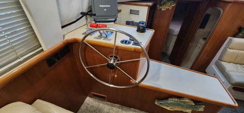 Slide: The Image of 1998 Carver 355 Aft Cabin Motor Yacht interior helm with steering wheel and navigation equipment. - 18