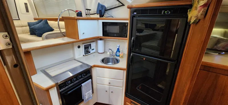 Slide: The Image of 1998 Carver 355 Aft Cabin Motor Yacht kitchen with stove, sink, and refrigerator. - 20