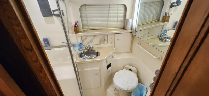 Slide: The Image of 1998 Carver 355 Aft Cabin Motor Yacht bathroom with sink, toilet, and mirror. - 27