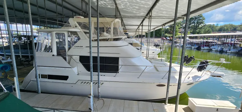 Slide: The Image of 1998 Carver 355 Aft Cabin Motor Yacht docked in a marina under a covered slip. - 3