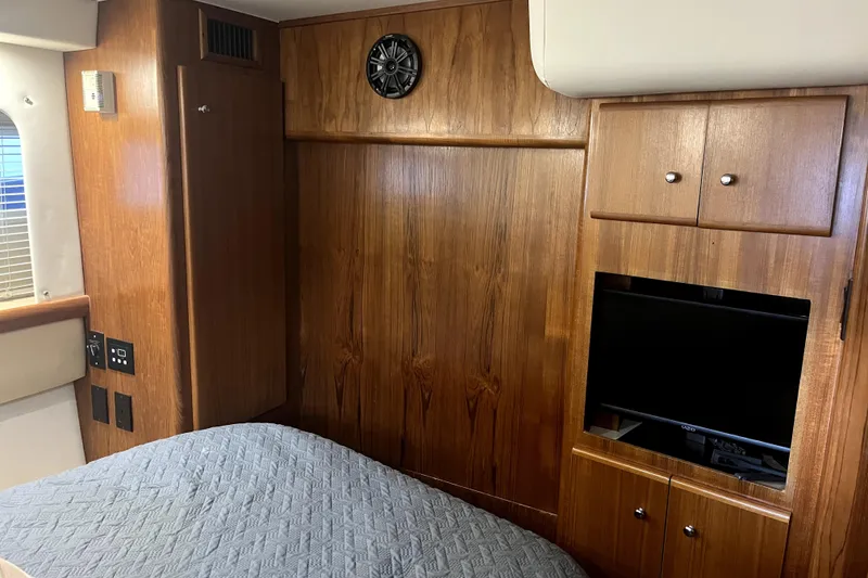 Slide: The Image of 1998 Carver 355 Aft Cabin interior with wood paneling, bed, and built-in TV. - 39