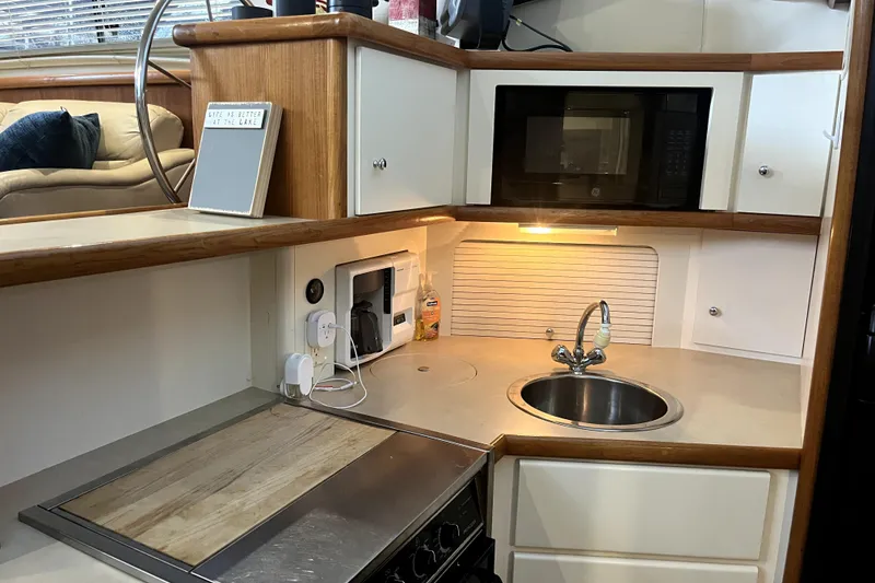 Slide: The Image of 1998 Carver 355 Aft Cabin kitchen with sink, microwave, and stove. - 40