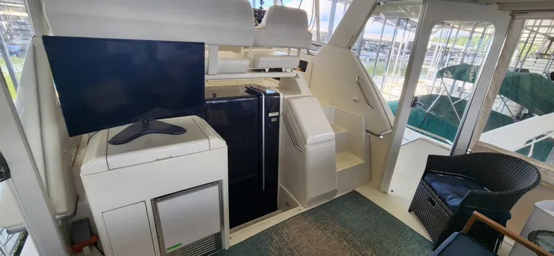Slide: The Image of 1998 Carver 355 Aft Cabin Motor Yacht interior with TV, fridge, and seating area. - 8