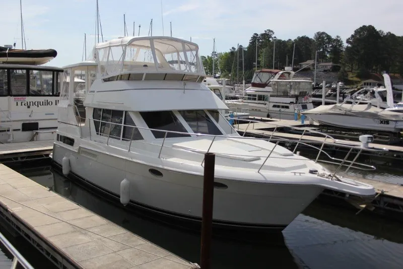 Slide: The Image of 1998 Carver 355 Aft Cabin Motor Yacht docked at marina, surrounded by other boats. - 1
