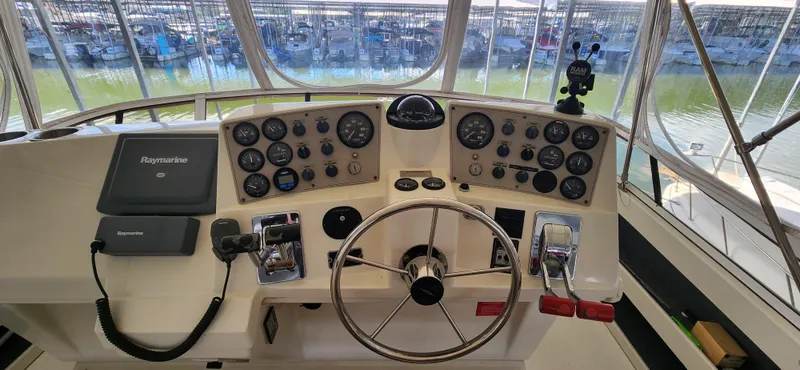 Slide: The Image of 1998 Carver 355 Aft Cabin Motor Yacht helm with gauges, steering wheel, and navigation equipment. - 11