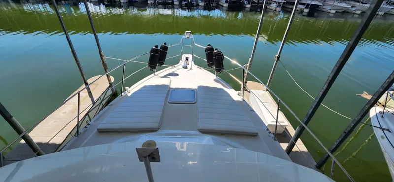 Slide: The Image of 1998 Carver 355 Aft Cabin Motor Yacht docked, featuring spacious deck and seating area. - 13