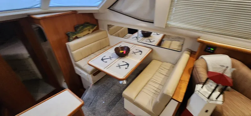 Slide: The Image of 1998 Carver 355 Aft Cabin Motor Yacht interior with dining area and seating. - 15