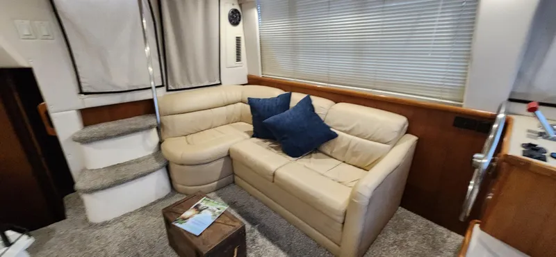 Slide: The Image of 1998 Carver 355 Aft Cabin Motor Yacht interior with beige sofa and blue cushions. - 17