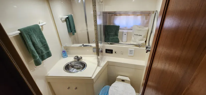 Slide: The Image of 1998 Carver 355 Aft Cabin Motor Yacht bathroom with sink, toilet, and towels. - 22