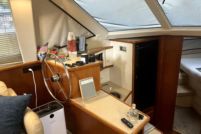 Slide: The Image of Interior of 1998 Carver 355 Aft Cabin with helm, kitchenette, and cozy seating area. - 34