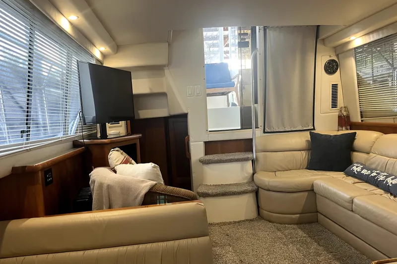 Slide: The Image of 1998 Carver 355 Aft Cabin interior with cozy seating, TV, and natural light. - 38