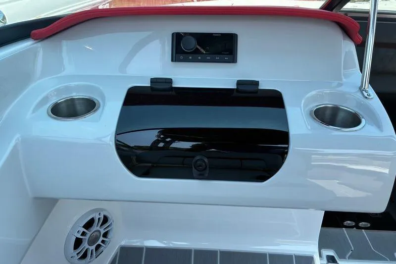 Slide: The Image of 2022 Regal LX2 boat dashboard with cup holders and audio system. - 16