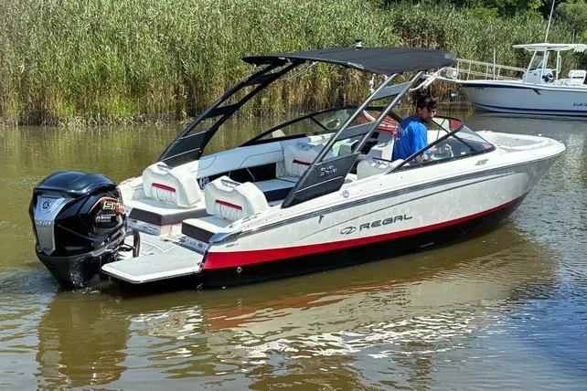 Slide: The Image of 2022 Regal LX2 boat with canopy cruising on a calm river. - 4