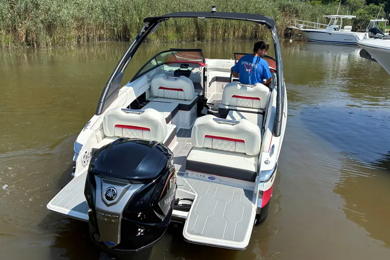 Slide: The Image of 2022 Regal LX2 boat with Yamaha engine, docked in calm waters, featuring spacious seating. - 6