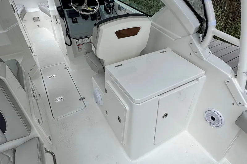Slide: The Image of 2026 Pursuit DC 266 Dual Console interior with helm, seating, and storage compartments. - 10